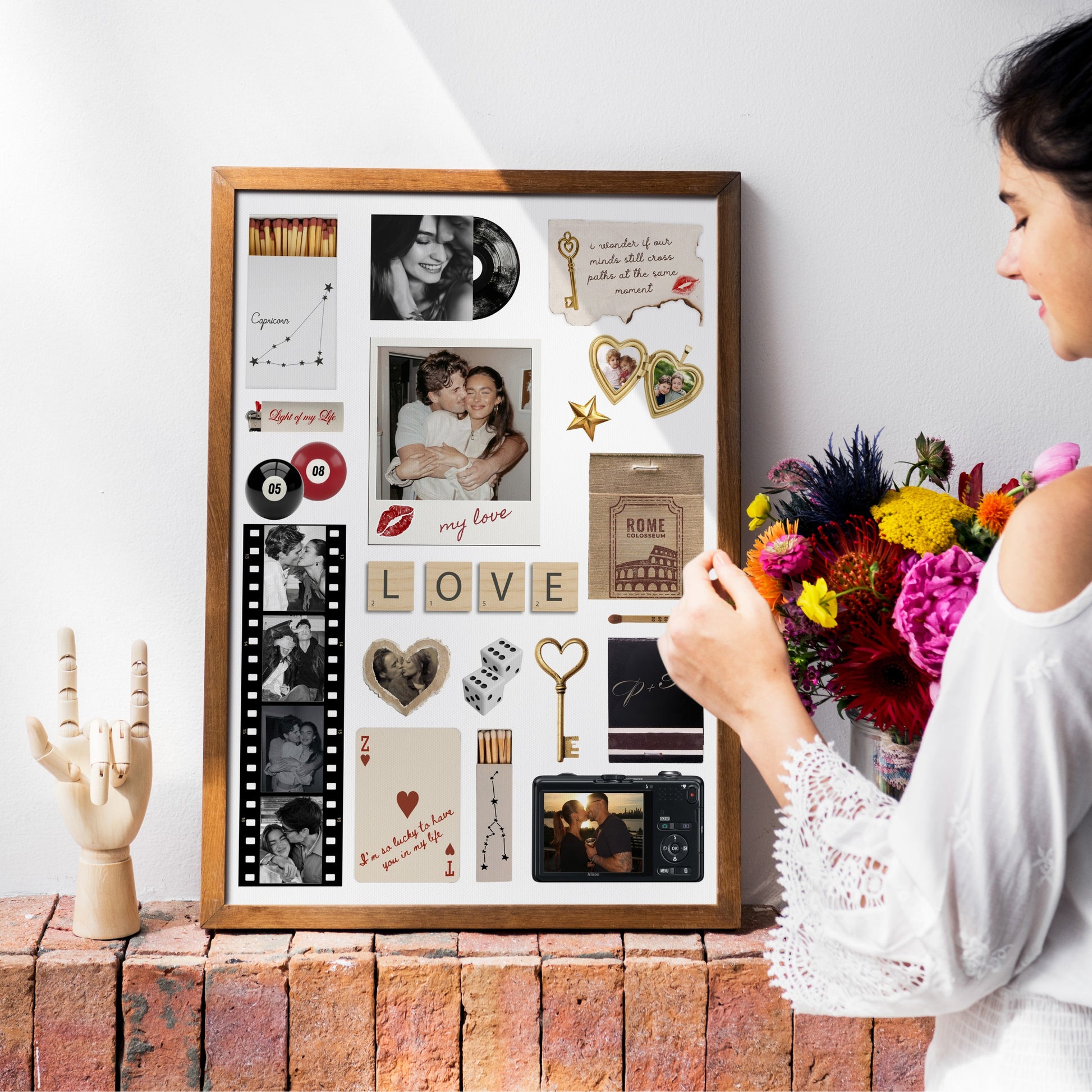 Eine Frau dekoriert ein gerahmtes, personalisiertes Matchbook-Poster als ästhetisches Wandbild neben einem Blumenstrauß.