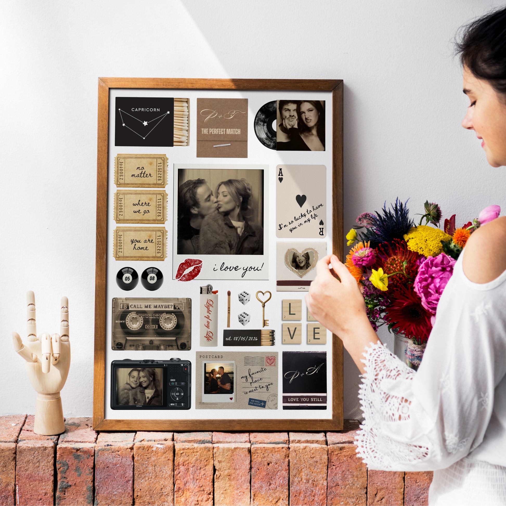 Eine Frau betrachtet das gerahmte Matchbook Poster mit persönlichen Fotos als Wanddeko über einem rustikalen Sims.