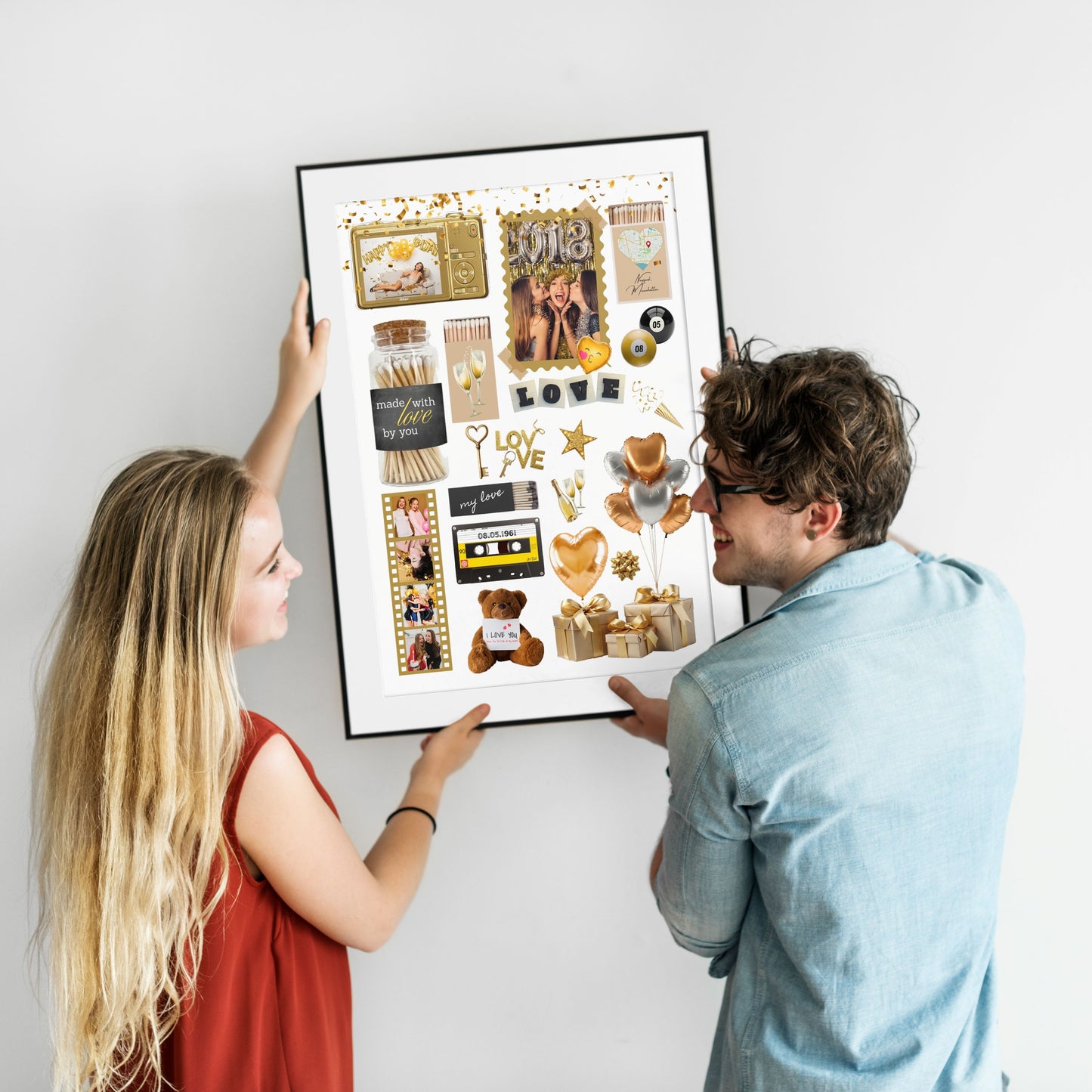 Ein lächelndes Paar hängt gemeinsam ein großes, gerahmtes Matchbook-Poster mit persönlichen Fotos an eine weiße Wand.