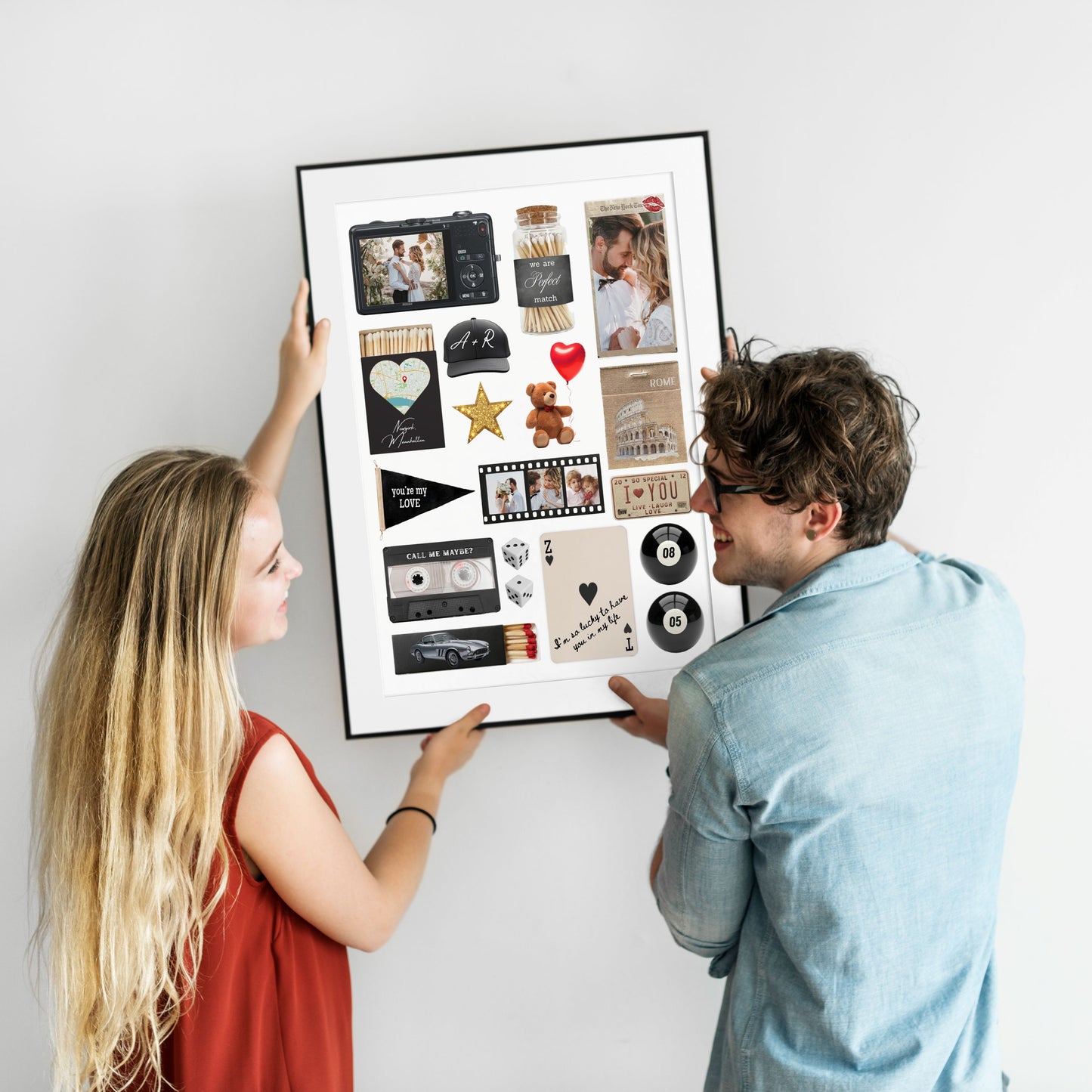 Ein glückliches Paar hängt ein gerahmtes, personalisiertes Matchbook-Poster als individuelle Wanddeko gemeinsam an eine Wand.