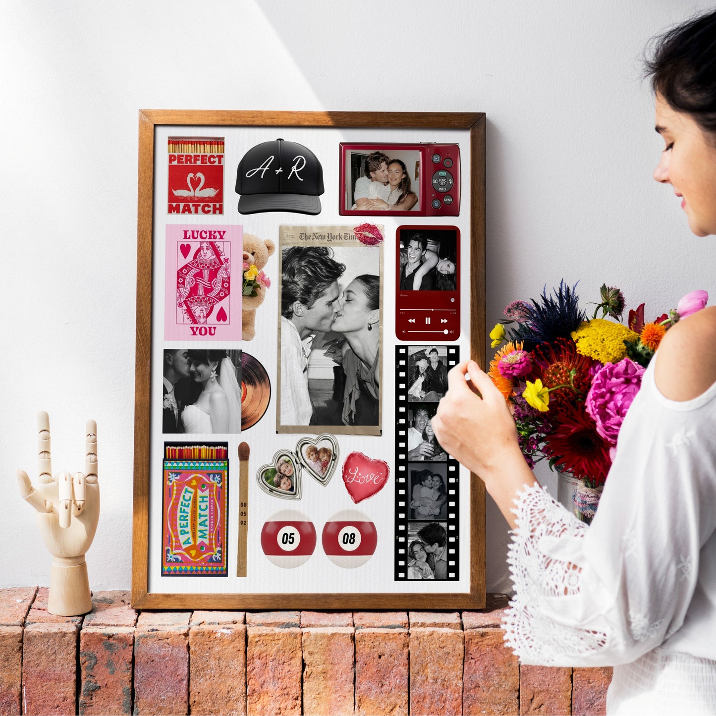 Eine Frau betrachtet ein gerahmtes, personalisiertes Matchbook-Poster mit Fotos und Collagen-Elementen an einer Wand.