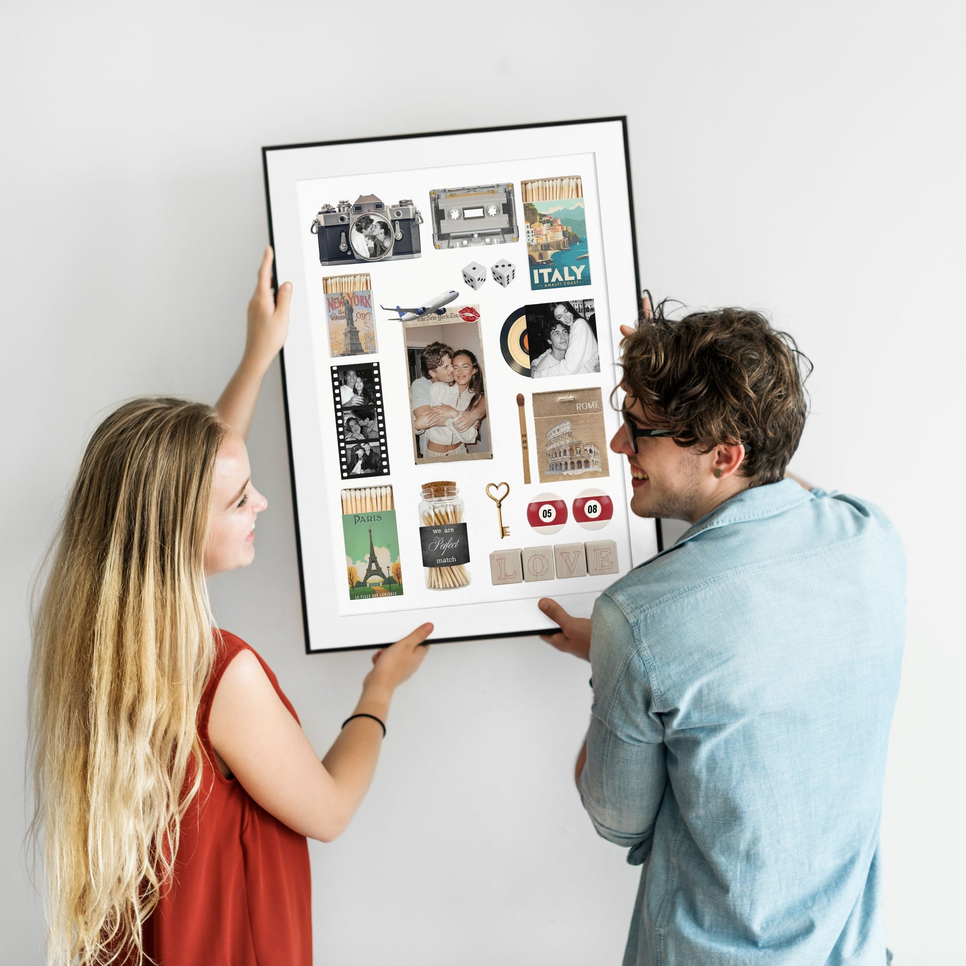 Ein lächelndes Paar hält gemeinsam ein gerahmtes, personalisiertes Matchbook Poster an eine weiße Wand.