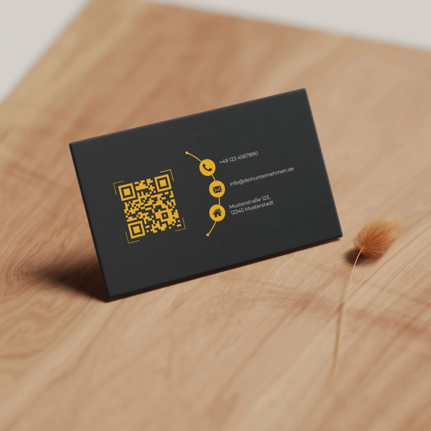 Realistische Vorschau der schwarz-gelben Visitenkarten Vorlage mit QR-Code und Kontaktdaten auf Holzoberfläche – Louvion.de