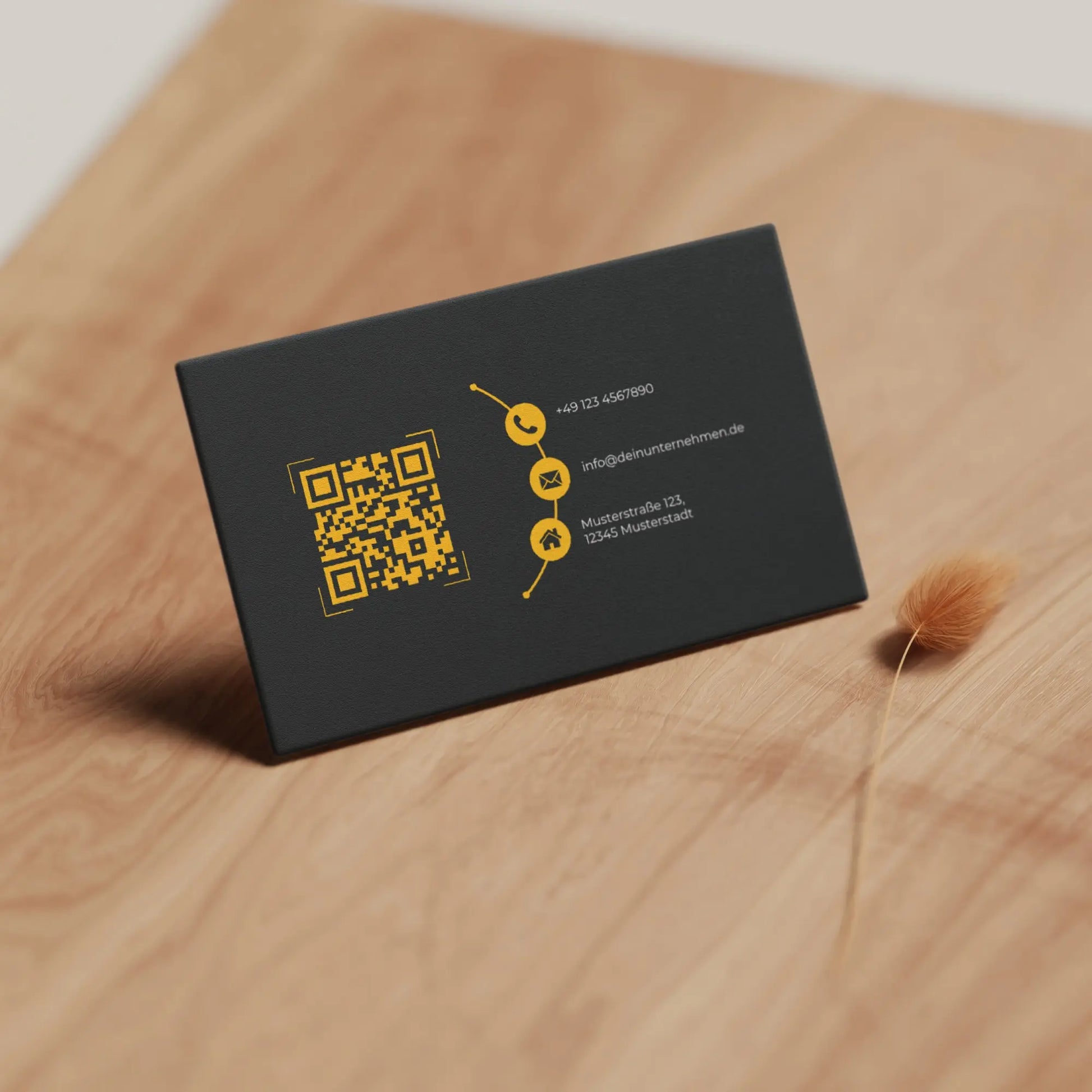 Realistische Vorschau der schwarz-gelben Visitenkarten Vorlage mit QR-Code und Kontaktdaten auf Holzoberfläche – Louvion.de